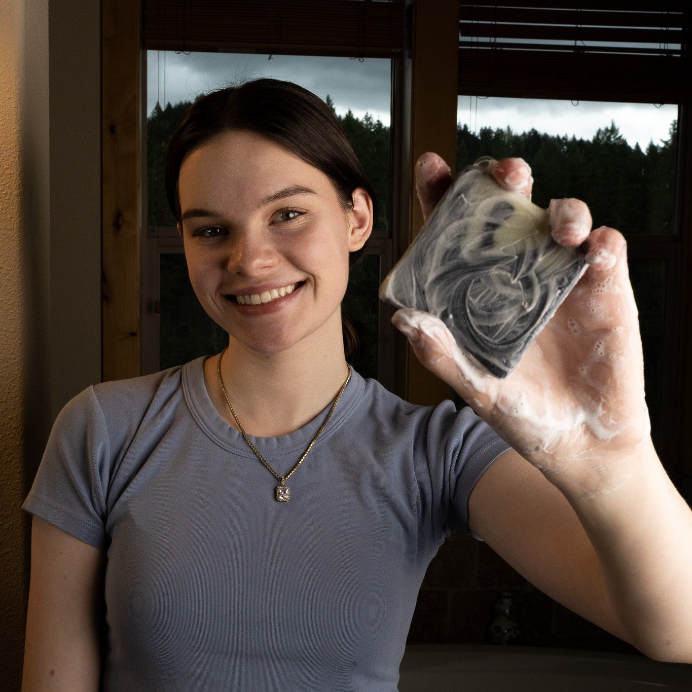 Person holding a bar of soap with a scenic background