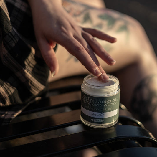 Person applying cream from a jar labeled 'Willamette' on a blurred background